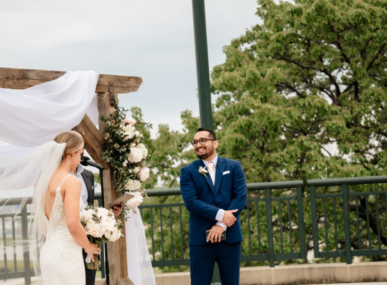 Outdoor ceremony, groom smiling at bride